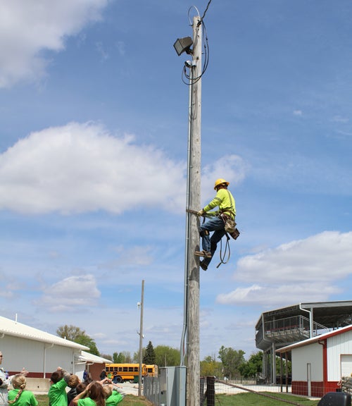 Lineworker climbing pole as demonstration